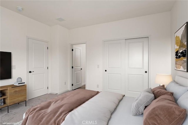 bedroom with light carpet and a closet