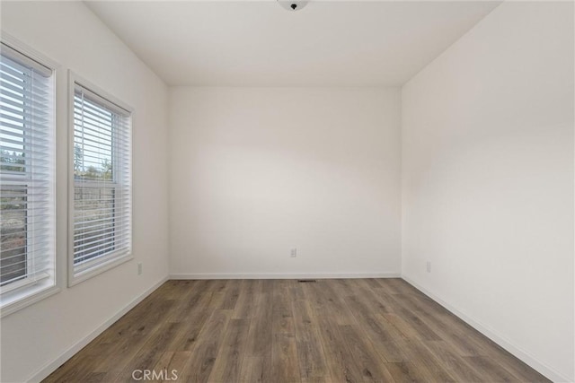 spare room featuring dark wood-type flooring