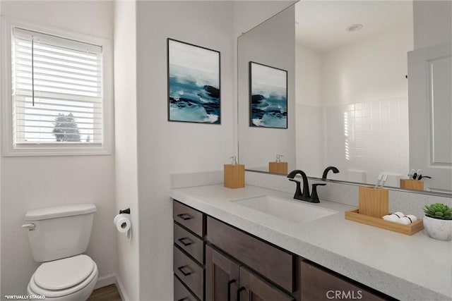 bathroom with a shower, vanity, and toilet