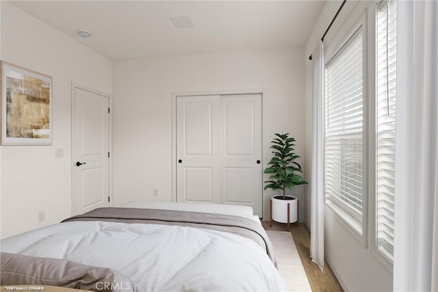 bedroom with light wood-type flooring and a closet