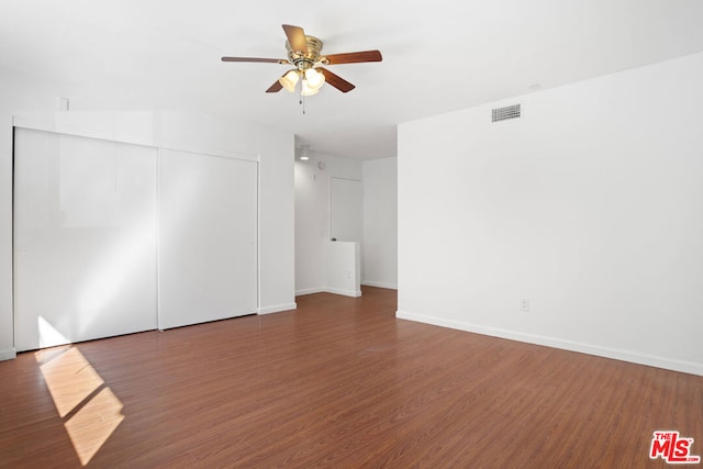 unfurnished room with ceiling fan and dark wood-type flooring