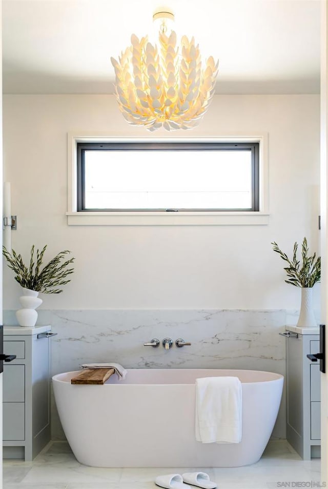 bathroom featuring a wealth of natural light, a bathtub, and tile walls