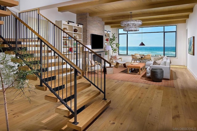 stairs featuring hardwood / wood-style flooring, a notable chandelier, beam ceiling, and wood ceiling