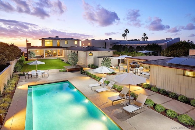 pool at dusk with a patio