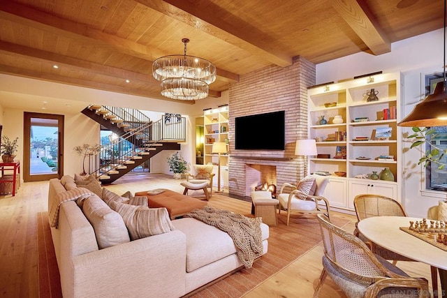 living room with wooden ceiling, light hardwood / wood-style floors, a fireplace, beam ceiling, and a chandelier