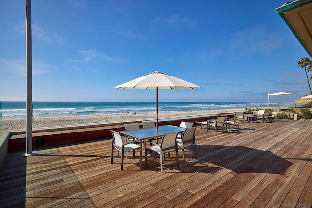 wooden terrace with a water view and a view of the beach