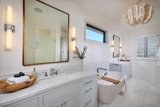 bathroom with vanity, a healthy amount of sunlight, and a tub