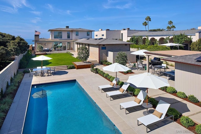 view of pool featuring a lawn and a patio area