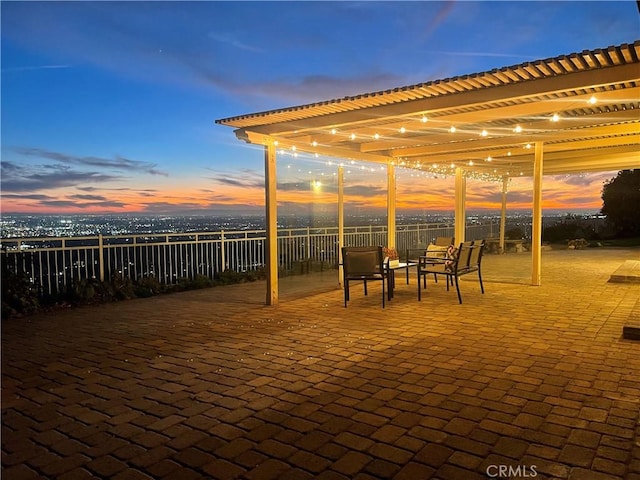 patio terrace at dusk featuring a pergola