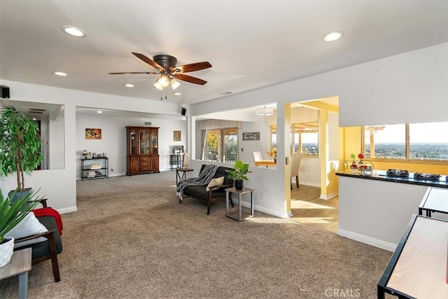 carpeted living room with ceiling fan