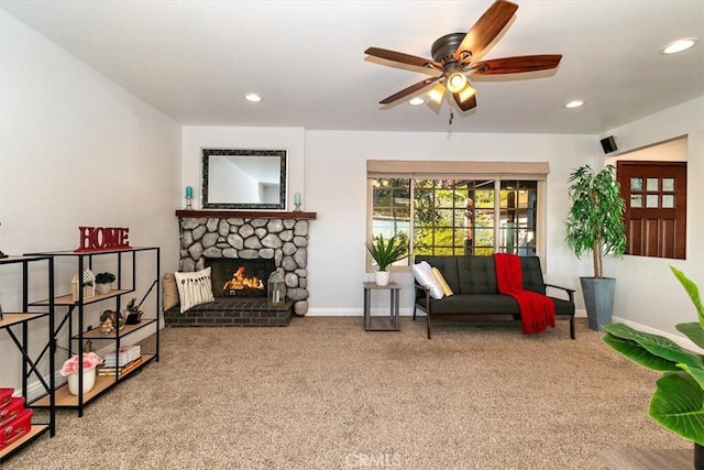 sitting room with ceiling fan, carpet flooring, and a fireplace