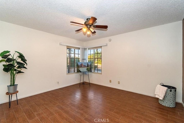 spare room with dark hardwood / wood-style floors, a textured ceiling, and ceiling fan