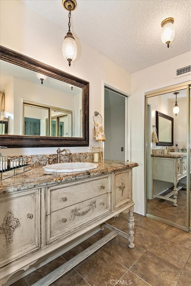 bathroom with vanity and a textured ceiling