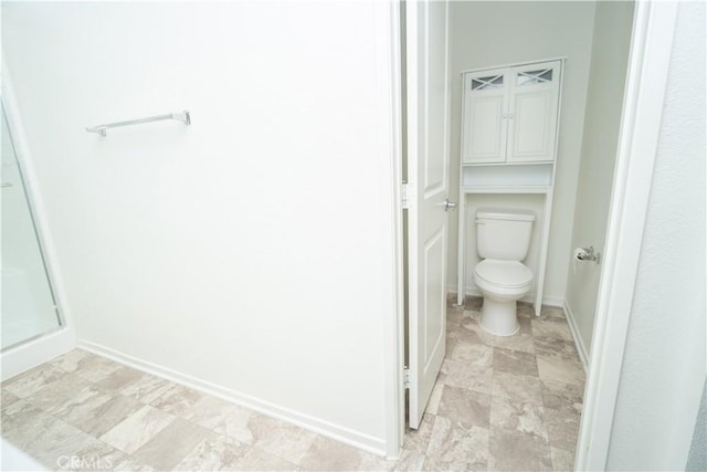 bathroom featuring toilet and a shower with door