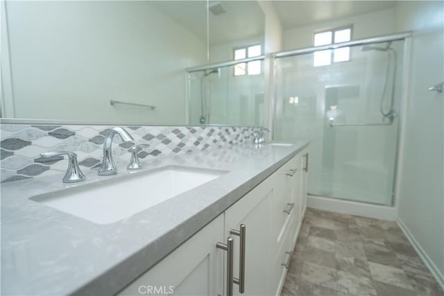 bathroom featuring decorative backsplash, vanity, and an enclosed shower