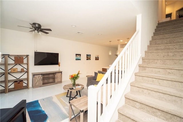 staircase featuring tile patterned floors and ceiling fan