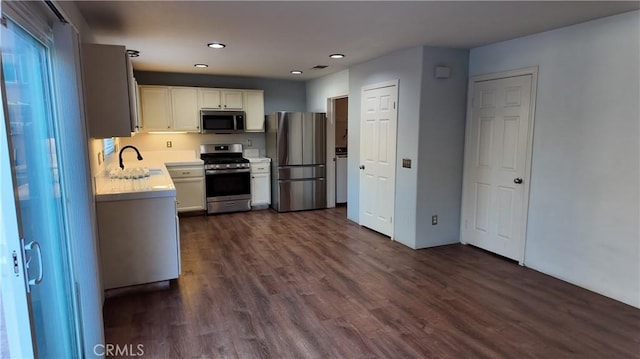 kitchen with white cabinetry, dark hardwood / wood-style flooring, stainless steel appliances, and sink