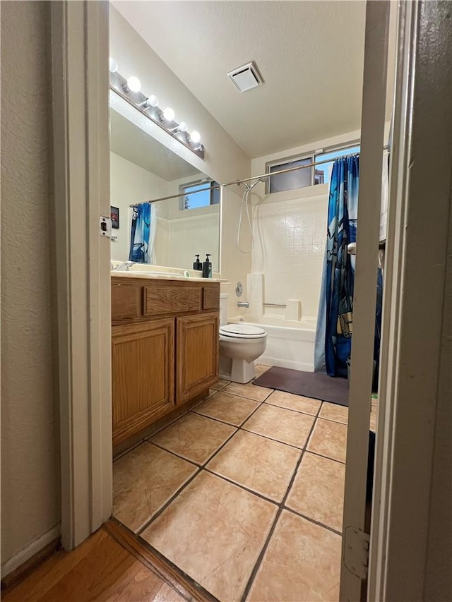 full bathroom featuring tile patterned flooring, vanity, toilet, and shower / bath combo with shower curtain