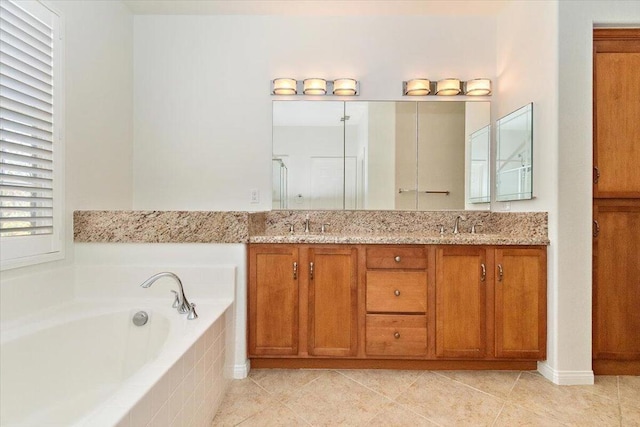 bathroom featuring tile patterned flooring, vanity, and tiled bath