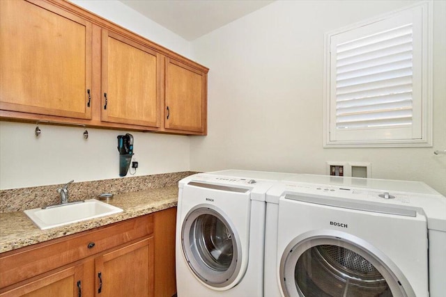 washroom with cabinets, separate washer and dryer, and sink