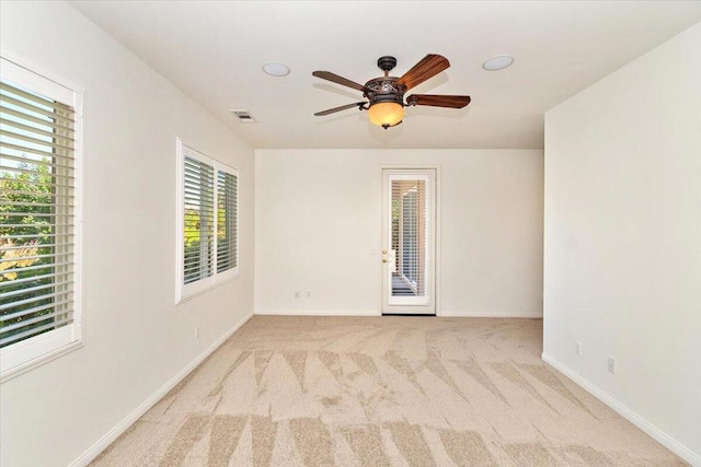 carpeted empty room featuring ceiling fan and a healthy amount of sunlight