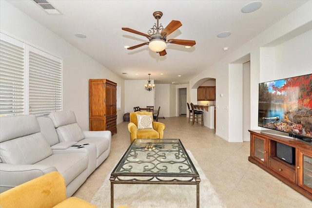 living room with ceiling fan with notable chandelier