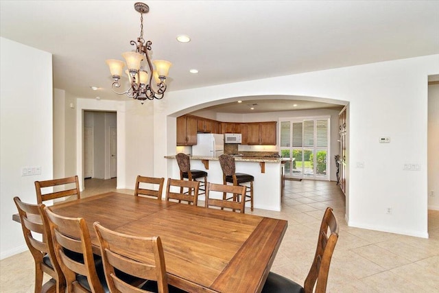 tiled dining room featuring a notable chandelier