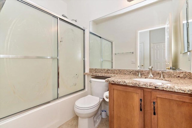 full bathroom with shower / bath combination with glass door, tile patterned flooring, vanity, and toilet