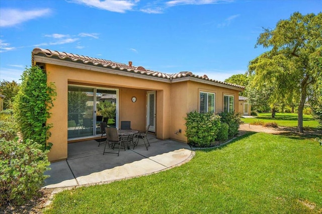 back of house featuring a yard and a patio