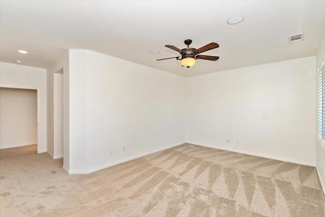 spare room with ceiling fan and light colored carpet