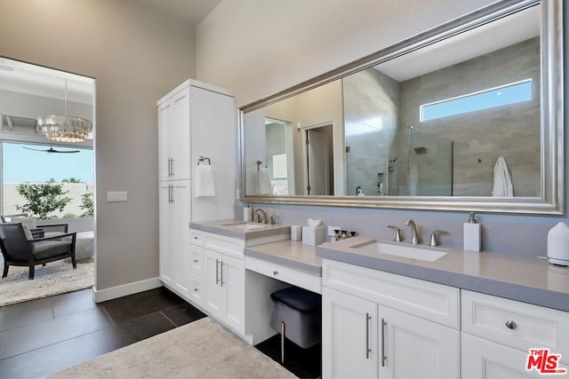 bathroom with tile patterned flooring, vanity, a chandelier, and walk in shower