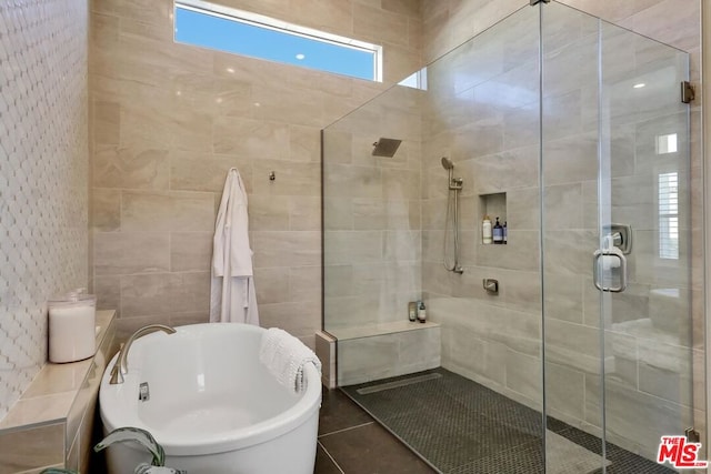 bathroom with tile patterned floors, tile walls, and independent shower and bath