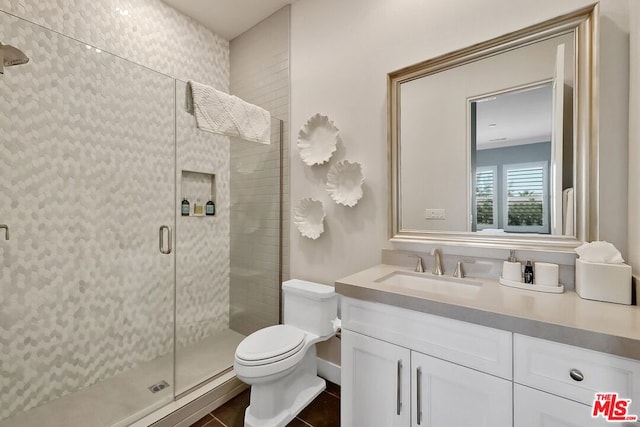 bathroom featuring tile patterned floors, vanity, toilet, and a shower with shower door