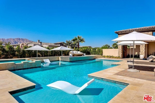 view of swimming pool featuring a mountain view, an in ground hot tub, and a patio