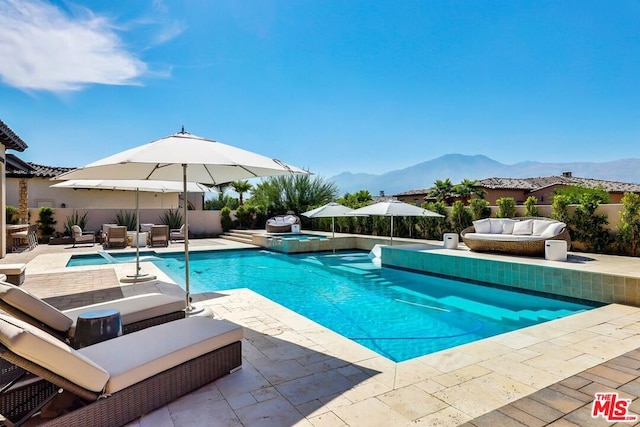 view of swimming pool featuring a mountain view, a patio area, and an outdoor hangout area