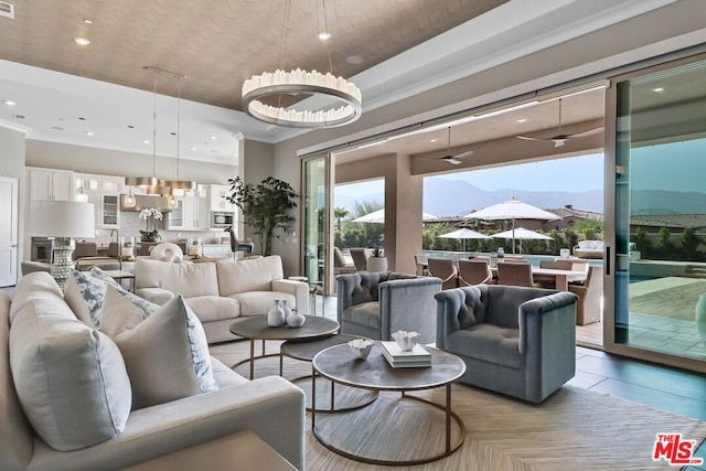 tiled living room with a mountain view, crown molding, and a chandelier