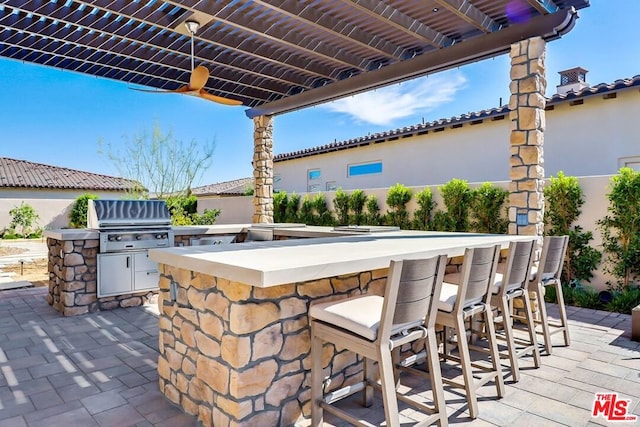 view of patio / terrace with an outdoor kitchen, a grill, and exterior bar