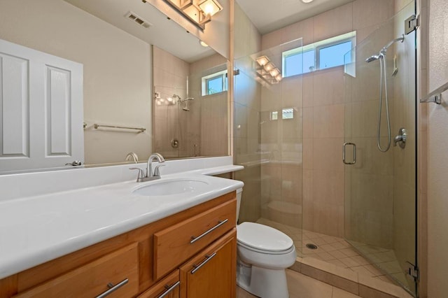 bathroom featuring tile patterned flooring, vanity, toilet, and an enclosed shower