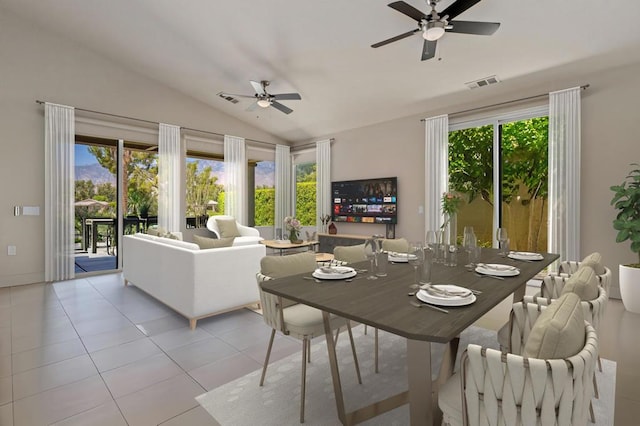 dining room with ceiling fan, plenty of natural light, light tile patterned floors, and vaulted ceiling