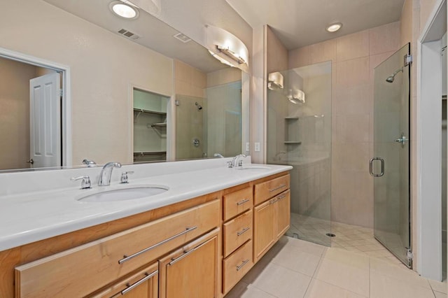 bathroom featuring tile patterned flooring, vanity, and an enclosed shower