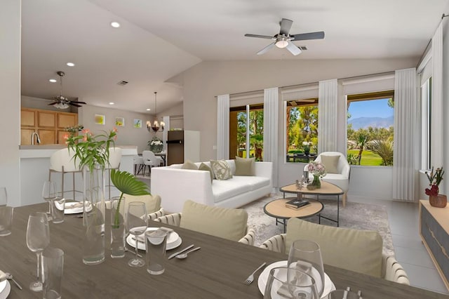 dining area with ceiling fan with notable chandelier, lofted ceiling, and a wealth of natural light