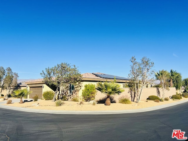 view of front of property featuring solar panels