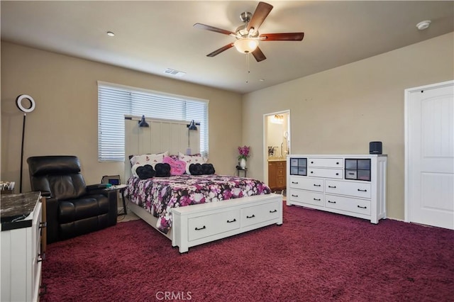 bedroom featuring dark colored carpet, ceiling fan, and ensuite bath