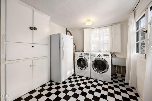 washroom featuring cabinets, sink, and washer and dryer