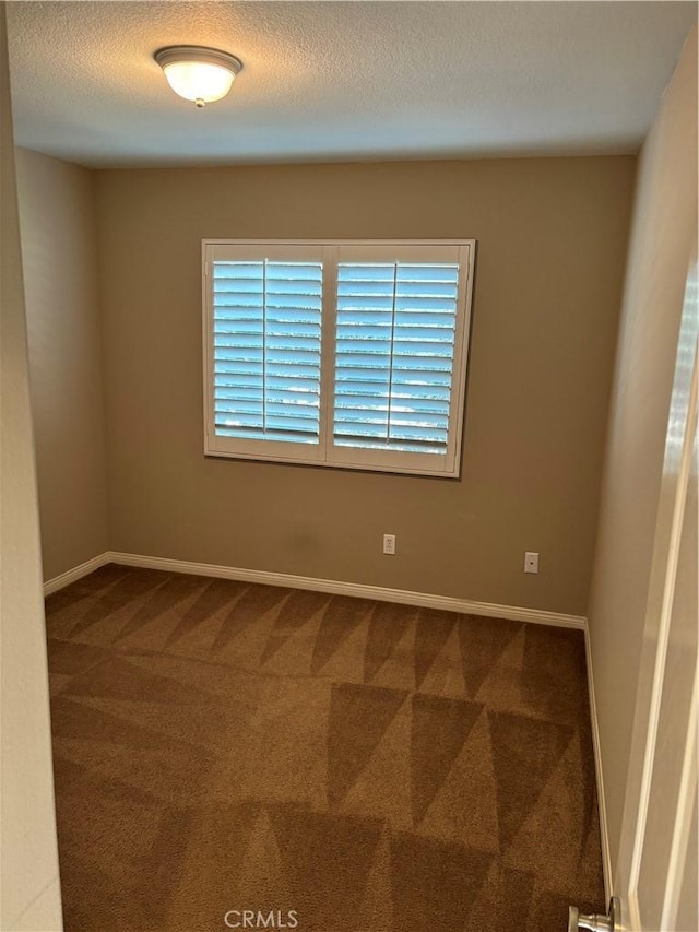 carpeted spare room featuring a textured ceiling