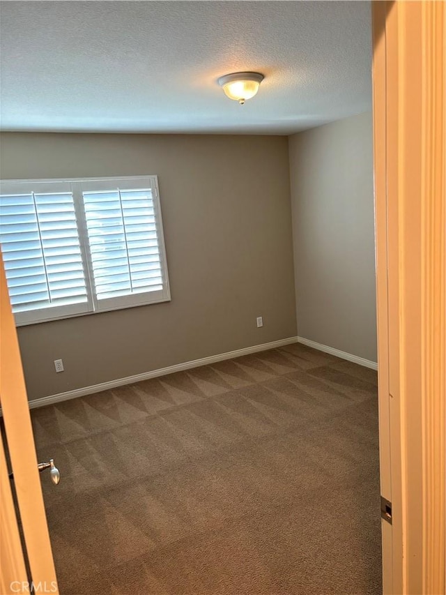 carpeted empty room with a textured ceiling