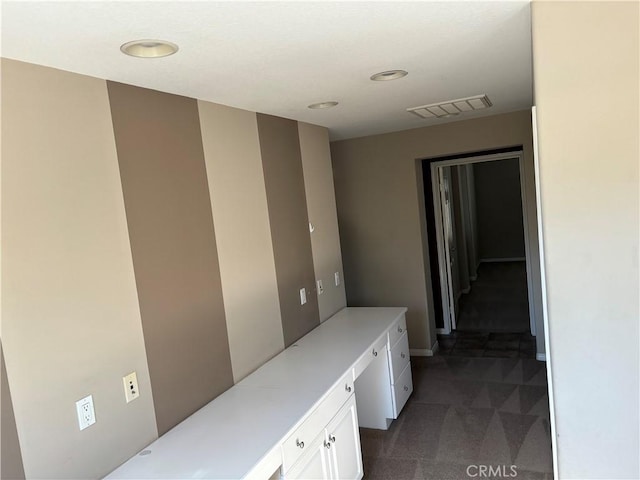 corridor with dark colored carpet