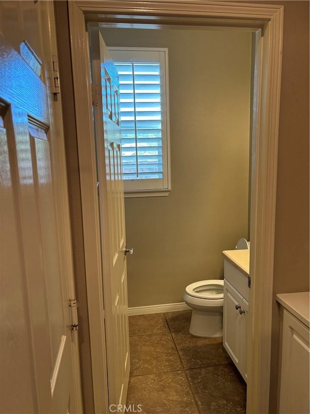 bathroom featuring tile patterned flooring, vanity, and toilet