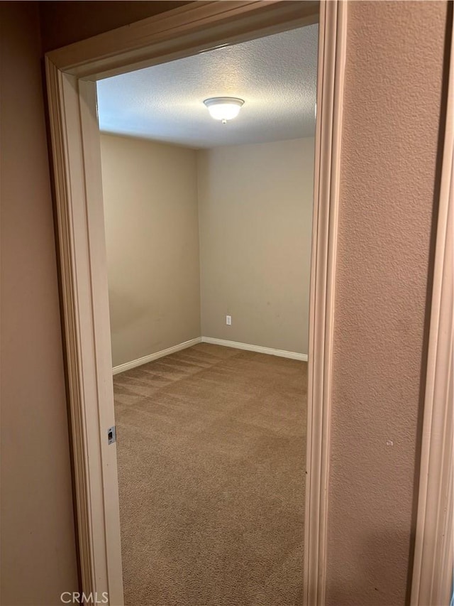 carpeted empty room with a textured ceiling