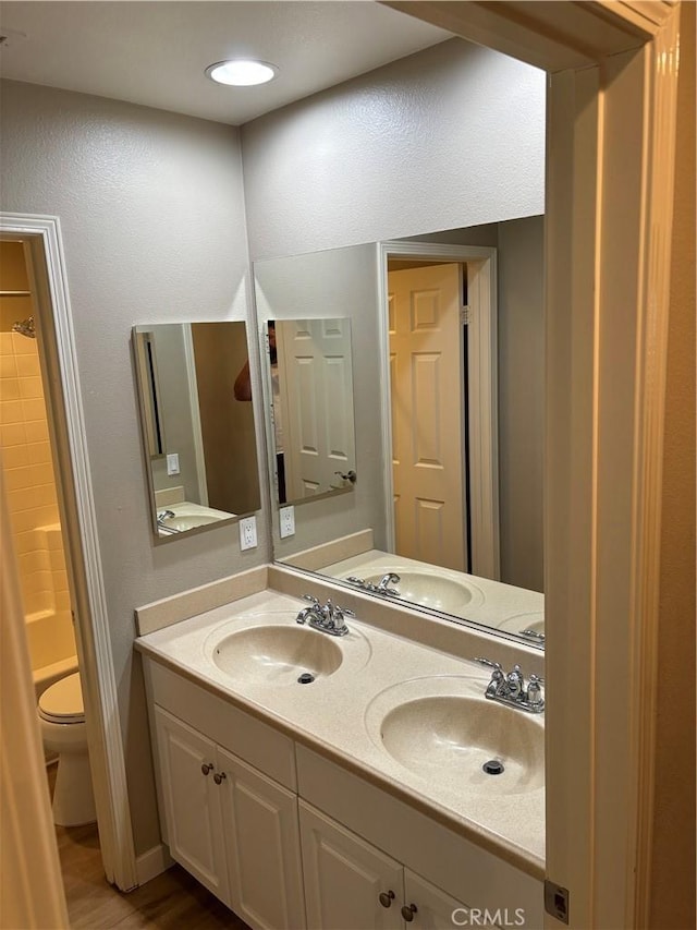 bathroom featuring walk in shower, hardwood / wood-style floors, vanity, and toilet